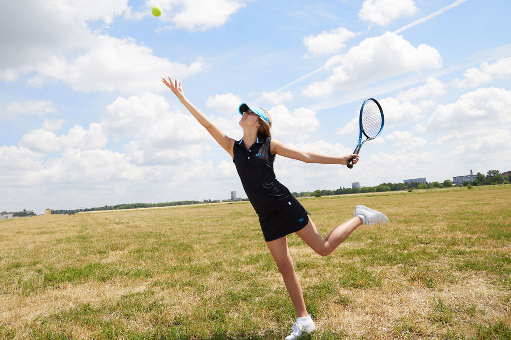 Tennisspielende Frau mir schwarzer Sportkind Kleidung