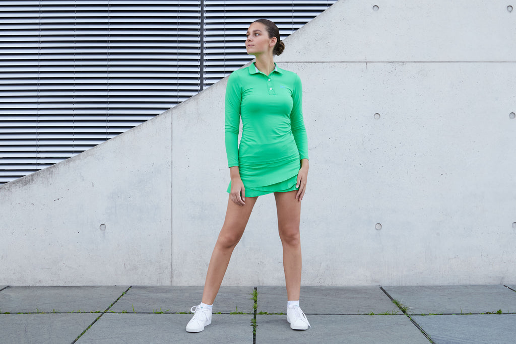 Frau mit grüner Sportkindkleidung bestehend aus Longsleeve Polo Shirt und Tulip Rock