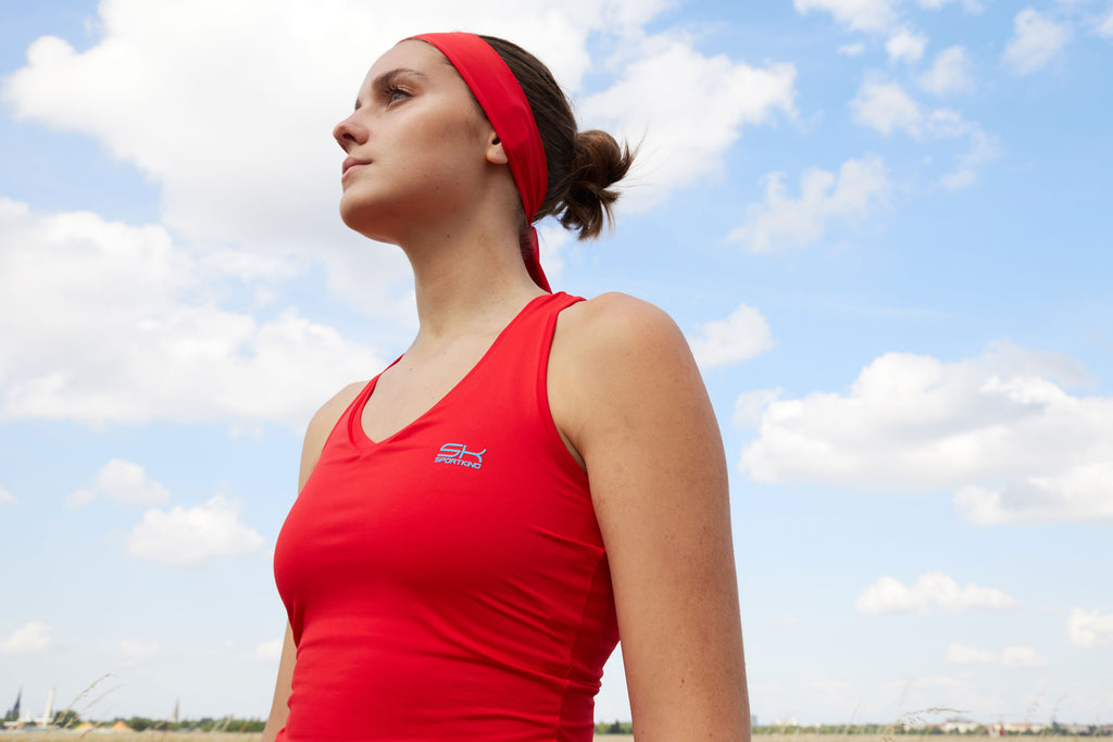 Frau in Sportbekleidung in Rot mit rotem Sport Top mit V-Ausschnitt und Stirnband