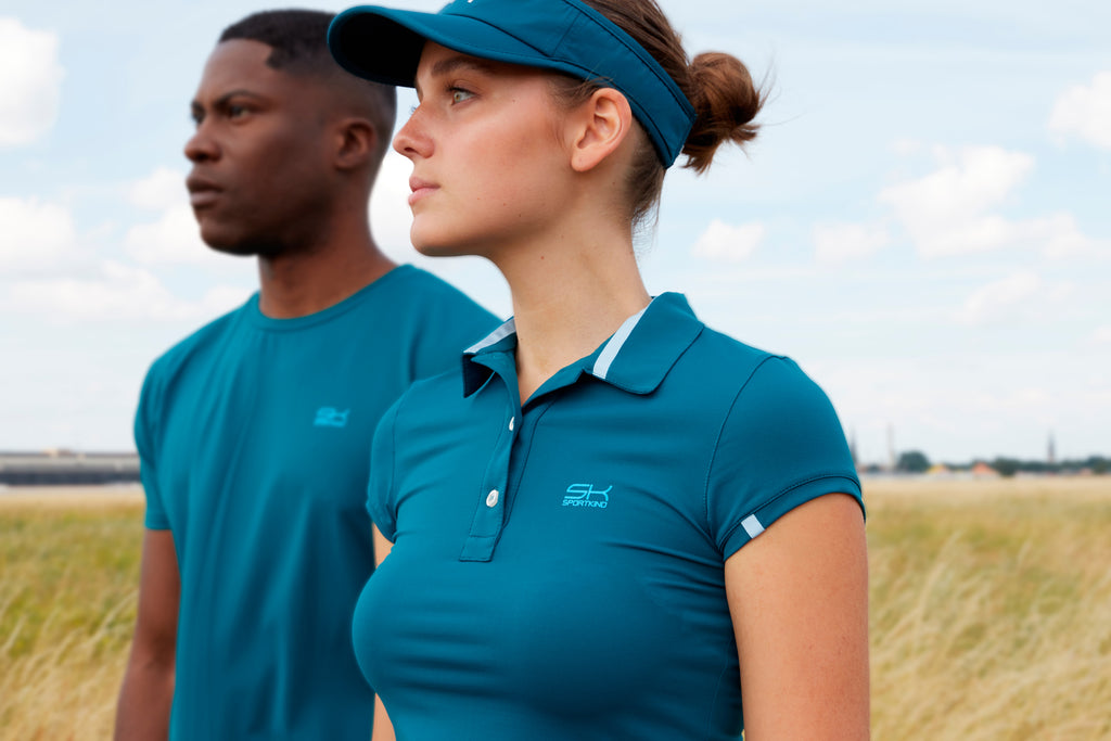 Frau mit petrolfarbenem Poloshirt und Sun Visor und Mann mit petrolfarbenen T-Shirt